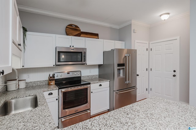 kitchen featuring white cabinetry, crown molding, stainless steel appliances, and light stone countertops