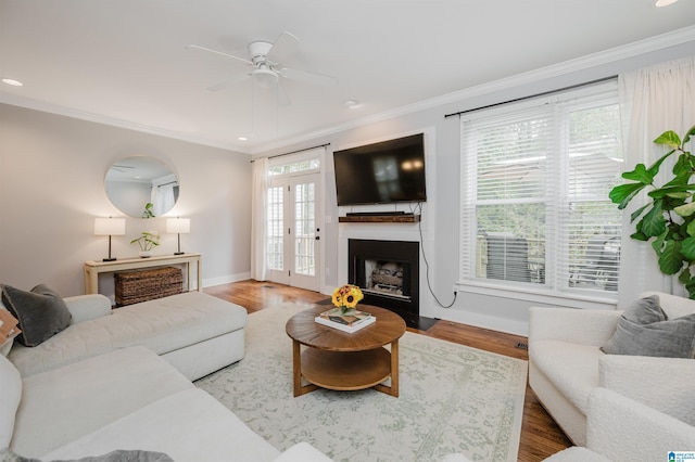 living room featuring hardwood / wood-style floors, crown molding, a healthy amount of sunlight, and ceiling fan