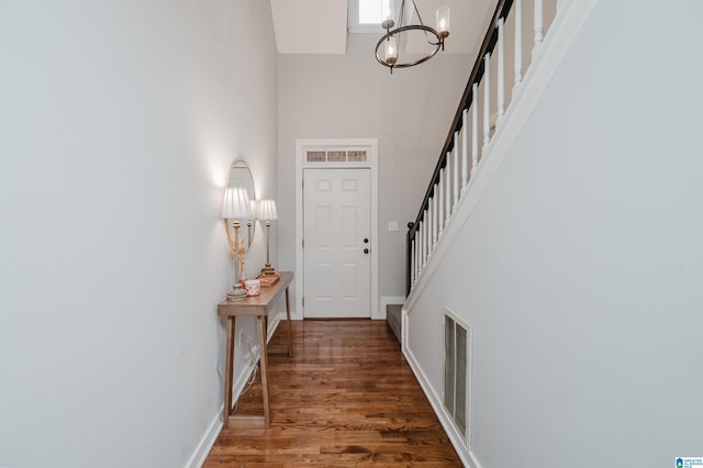 entrance foyer with an inviting chandelier, a high ceiling, and dark hardwood / wood-style floors