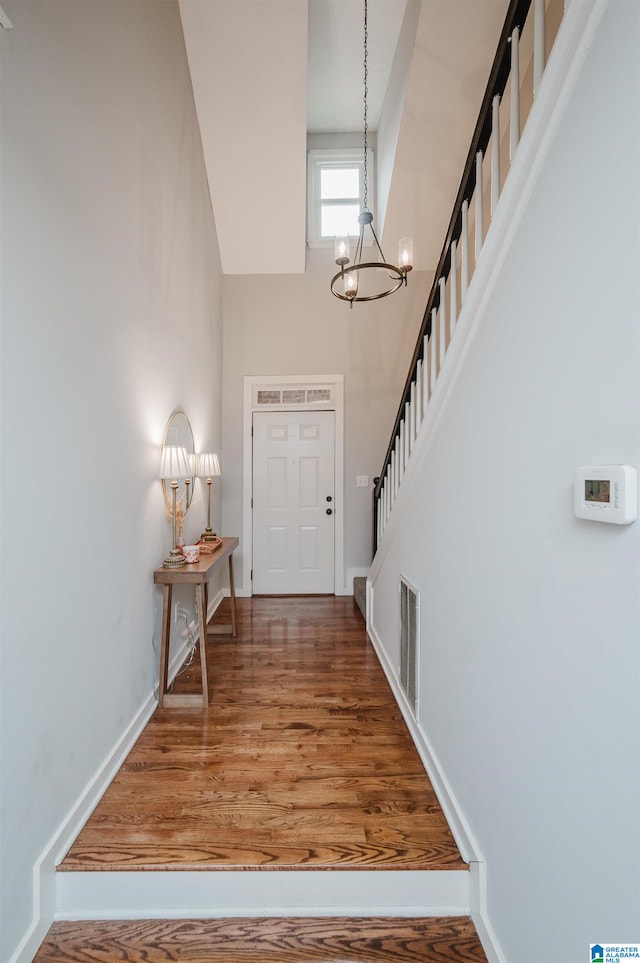 foyer entrance featuring wood-type flooring and a high ceiling