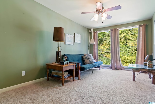 living area with carpet floors and ceiling fan