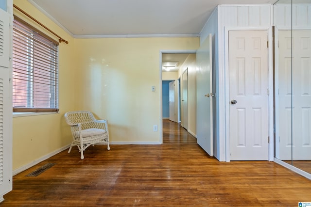 sitting room with crown molding and hardwood / wood-style flooring