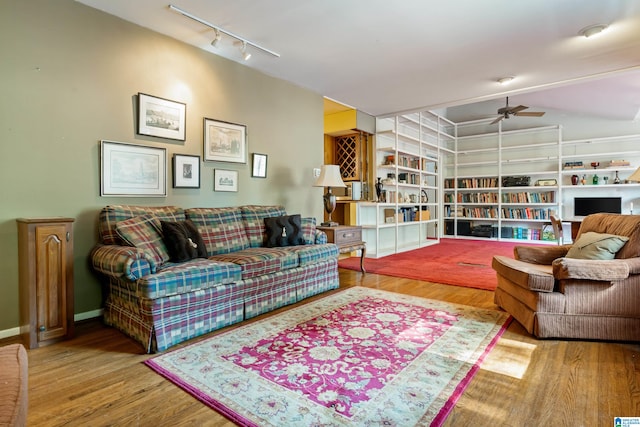 living room with wood-type flooring, rail lighting, and ceiling fan