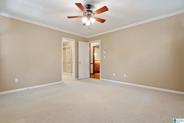 spare room with ornamental molding, light carpet, a textured ceiling, and ceiling fan