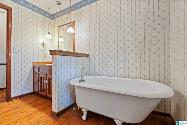 bathroom with hardwood / wood-style floors, a textured ceiling, and a bathtub