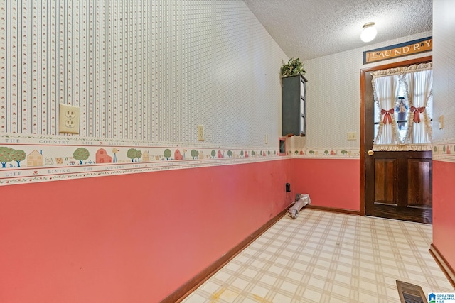 interior space with vaulted ceiling and a textured ceiling