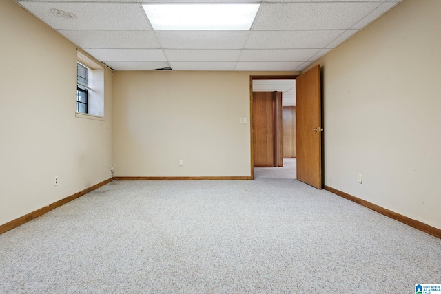 empty room with carpet flooring and a paneled ceiling