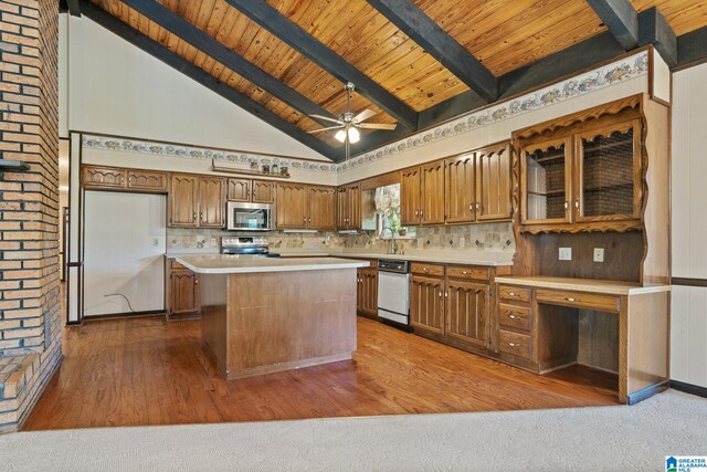 kitchen with beamed ceiling, a center island, stainless steel appliances, and wood-type flooring