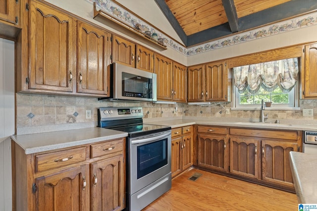 kitchen with wood ceiling, appliances with stainless steel finishes, light wood-type flooring, vaulted ceiling with beams, and sink