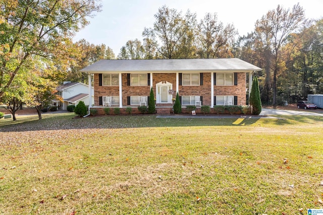 split foyer home featuring covered porch, a front yard, and a garage