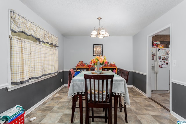 dining area with a notable chandelier and a textured ceiling