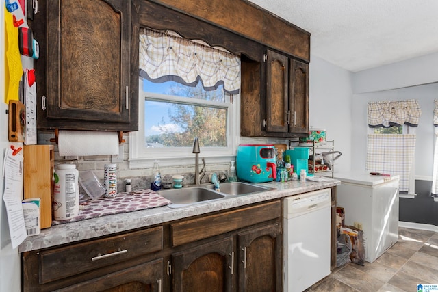 kitchen with sink, backsplash, dark brown cabinets, and dishwasher