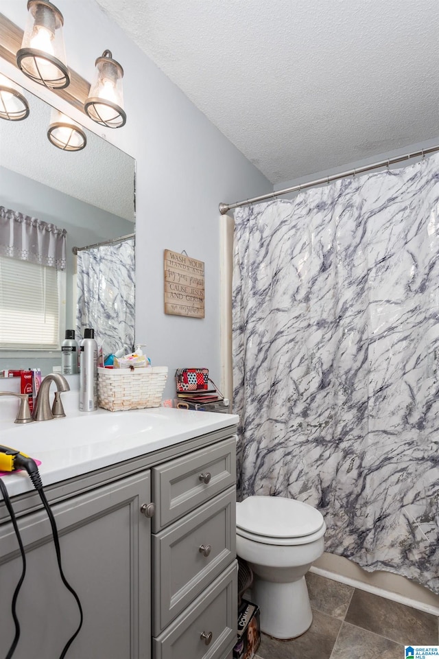 bathroom featuring vanity, toilet, a textured ceiling, and curtained shower