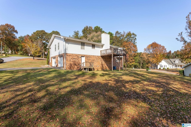 view of home's exterior with a wooden deck, a lawn, and a garage