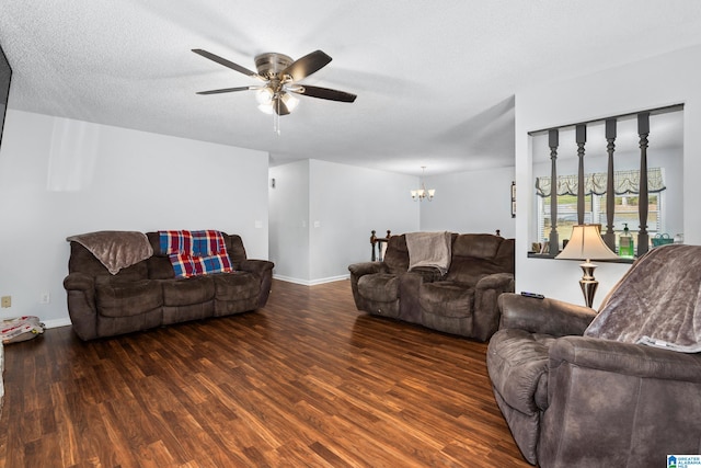 living room with a textured ceiling, dark hardwood / wood-style floors, and ceiling fan with notable chandelier