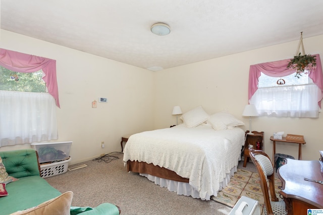 bedroom featuring light carpet and multiple windows