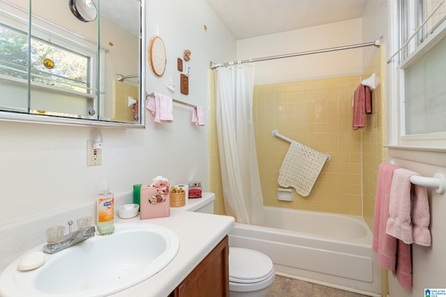 full bathroom featuring tile patterned floors, toilet, shower / bath combo with shower curtain, vanity, and a textured ceiling