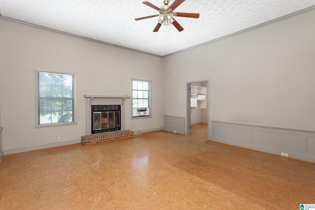 unfurnished living room with ceiling fan, ornamental molding, and a brick fireplace