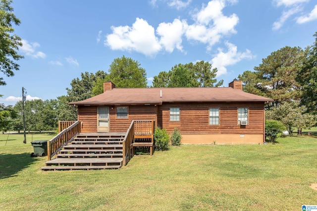 rear view of property with a wooden deck and a lawn