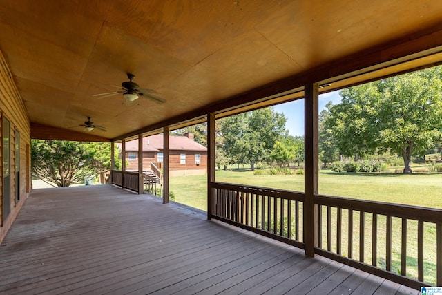 wooden deck featuring a lawn and ceiling fan