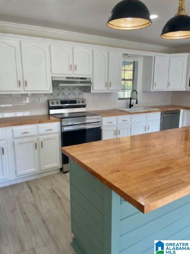 kitchen featuring wooden counters, white cabinets, hanging light fixtures, exhaust hood, and appliances with stainless steel finishes