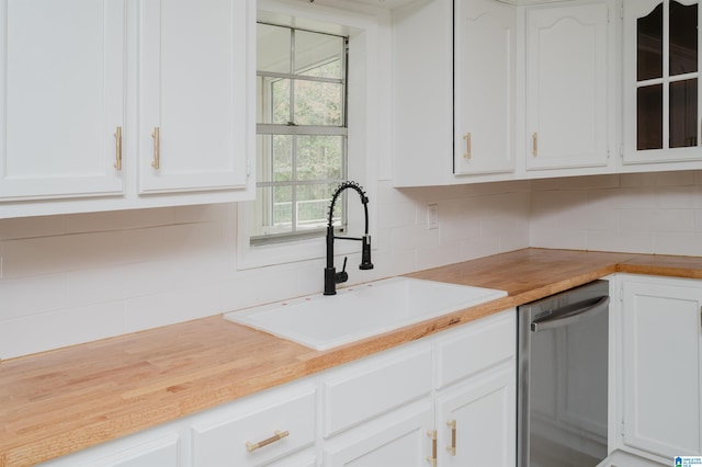 kitchen featuring white cabinetry, tasteful backsplash, stainless steel dishwasher, and sink