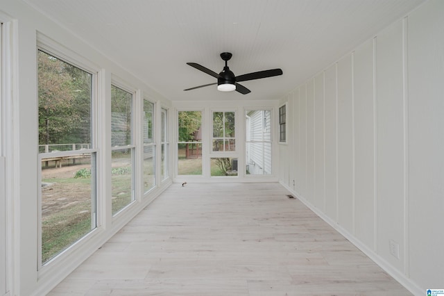 unfurnished sunroom with a wealth of natural light and ceiling fan