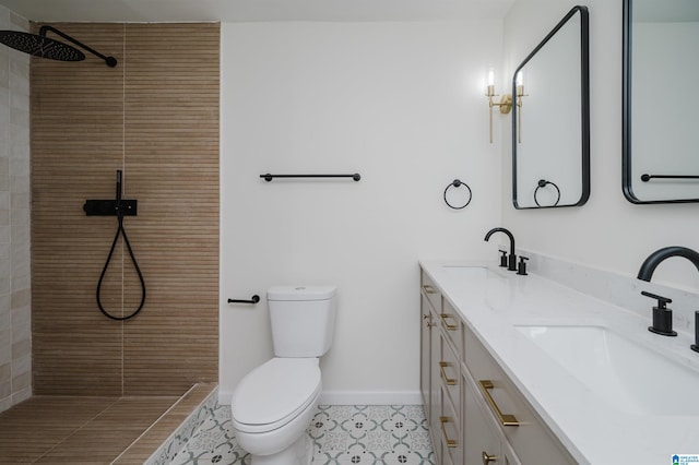 bathroom featuring toilet, vanity, tile patterned floors, and tiled shower