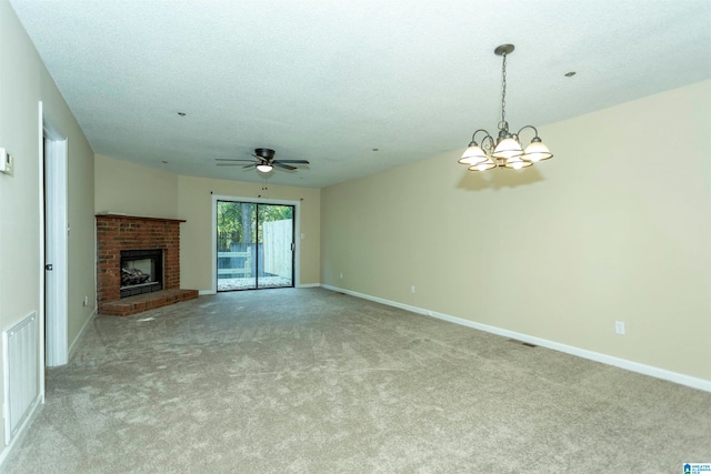 unfurnished living room with light carpet, a textured ceiling, ceiling fan with notable chandelier, and a fireplace