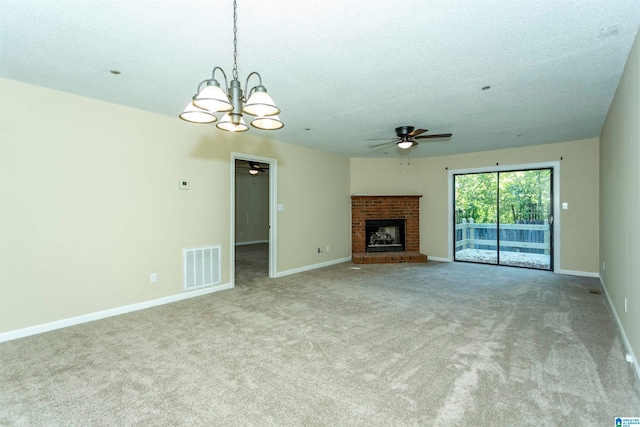 unfurnished living room with light colored carpet, a fireplace, a textured ceiling, and ceiling fan with notable chandelier