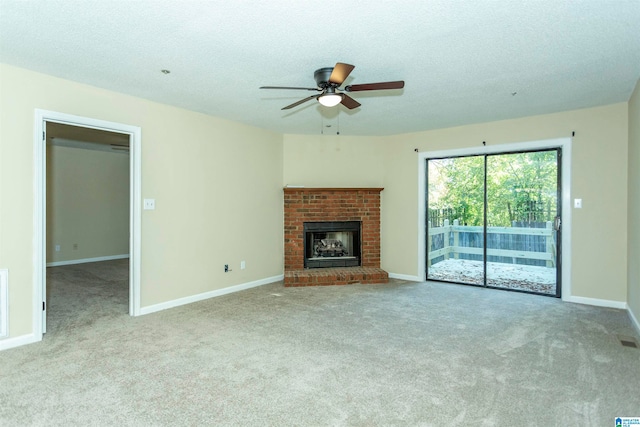 unfurnished living room with ceiling fan, a textured ceiling, a brick fireplace, and light colored carpet