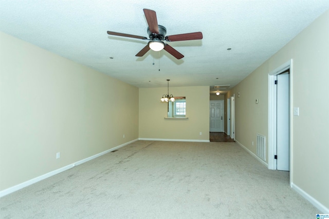 spare room featuring a textured ceiling, light colored carpet, and ceiling fan with notable chandelier