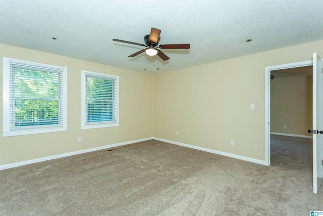 carpeted spare room with a textured ceiling and ceiling fan