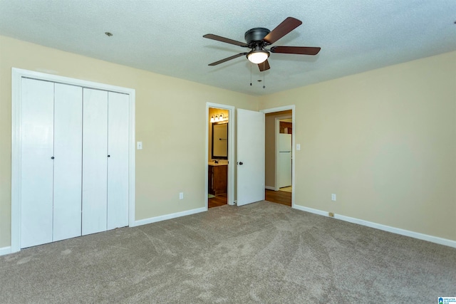 unfurnished bedroom with carpet, ceiling fan, ensuite bathroom, a closet, and white refrigerator