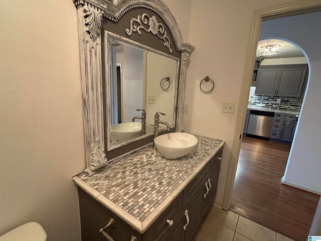 bathroom featuring hardwood / wood-style flooring, vanity, and decorative backsplash