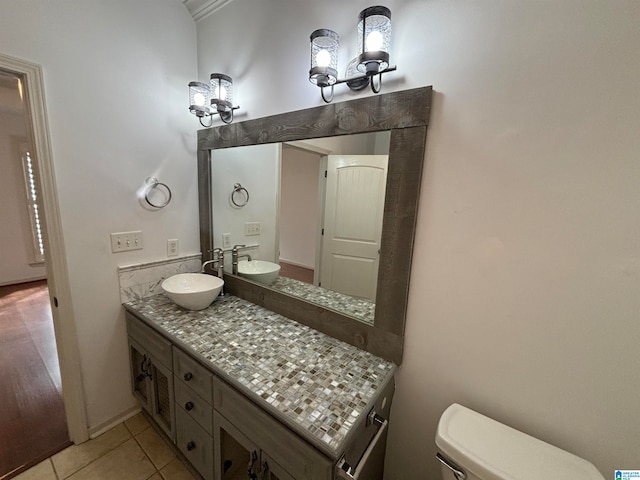 bathroom with toilet, vanity, and tile patterned flooring