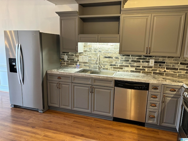 kitchen with stainless steel appliances, sink, dark hardwood / wood-style floors, backsplash, and gray cabinetry