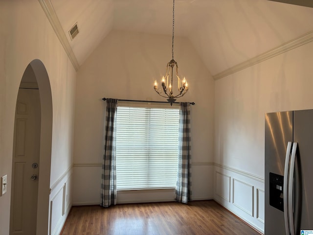 unfurnished dining area with a chandelier, lofted ceiling, hardwood / wood-style floors, and ornamental molding