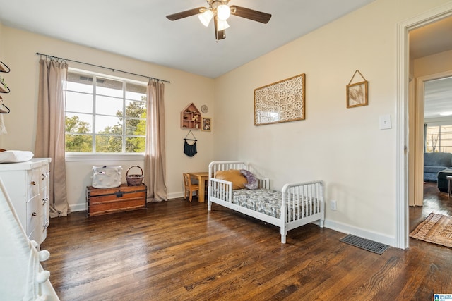 bedroom featuring multiple windows, dark wood-type flooring, and ceiling fan