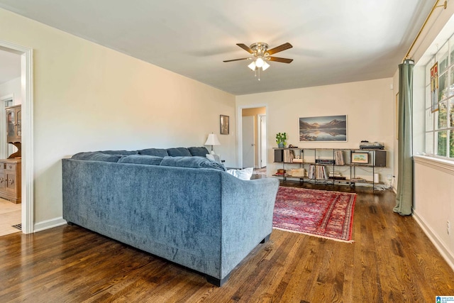 living room featuring ceiling fan and dark hardwood / wood-style floors