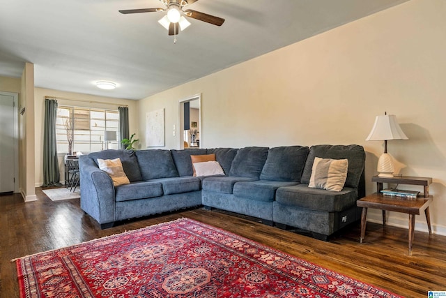 living room featuring ceiling fan and dark hardwood / wood-style flooring