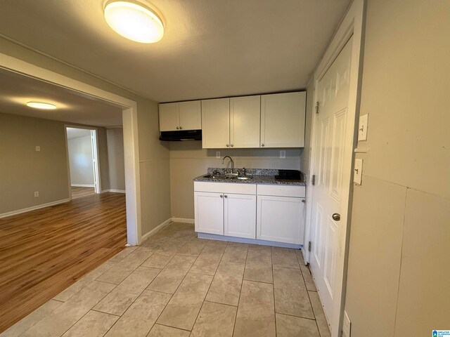 kitchen featuring white cabinetry, light hardwood / wood-style flooring, and sink