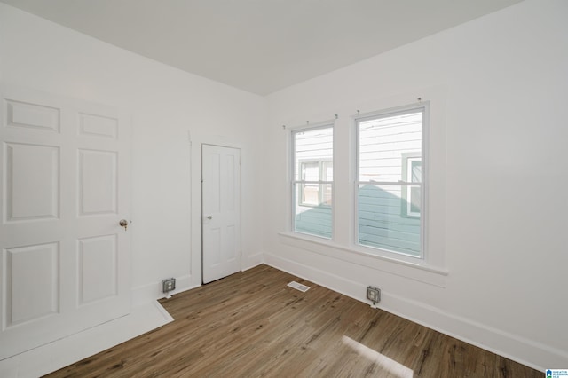 unfurnished room with wood-type flooring