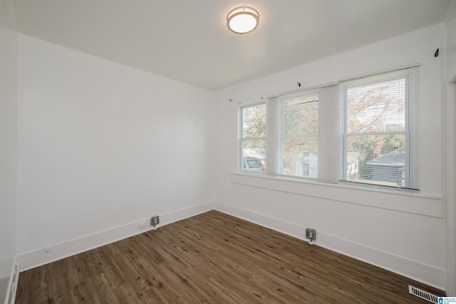 unfurnished room with dark wood-type flooring