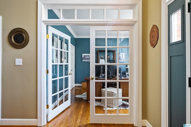 doorway featuring crown molding and hardwood / wood-style floors