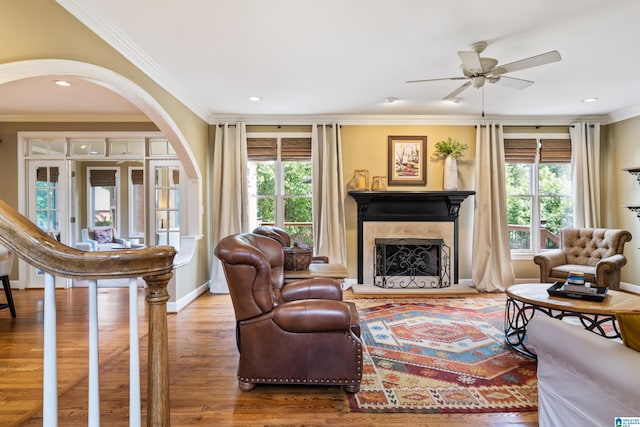 living room featuring crown molding, a healthy amount of sunlight, and wood-type flooring