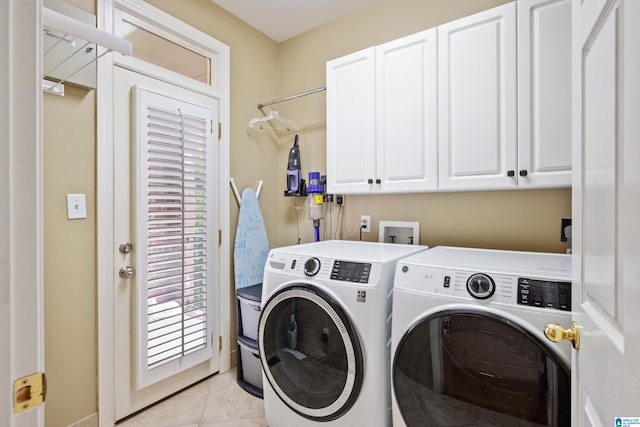 clothes washing area with light tile patterned flooring, cabinets, and separate washer and dryer