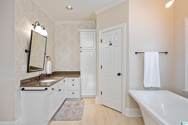 bathroom with vanity, ornamental molding, and a tub