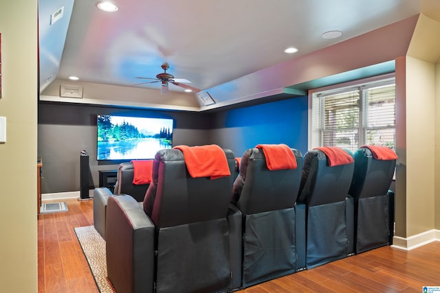 cinema featuring light wood-type flooring and ceiling fan