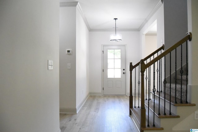 entrance foyer featuring stairs, crown molding, baseboards, and light wood finished floors